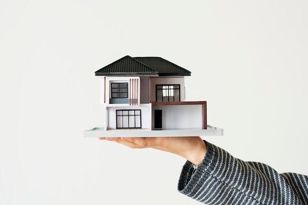 Free photo hand presenting model house for home loan campaign